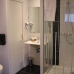 bathroom with shower and hairdryer - appart hotel bretagne bord de mer